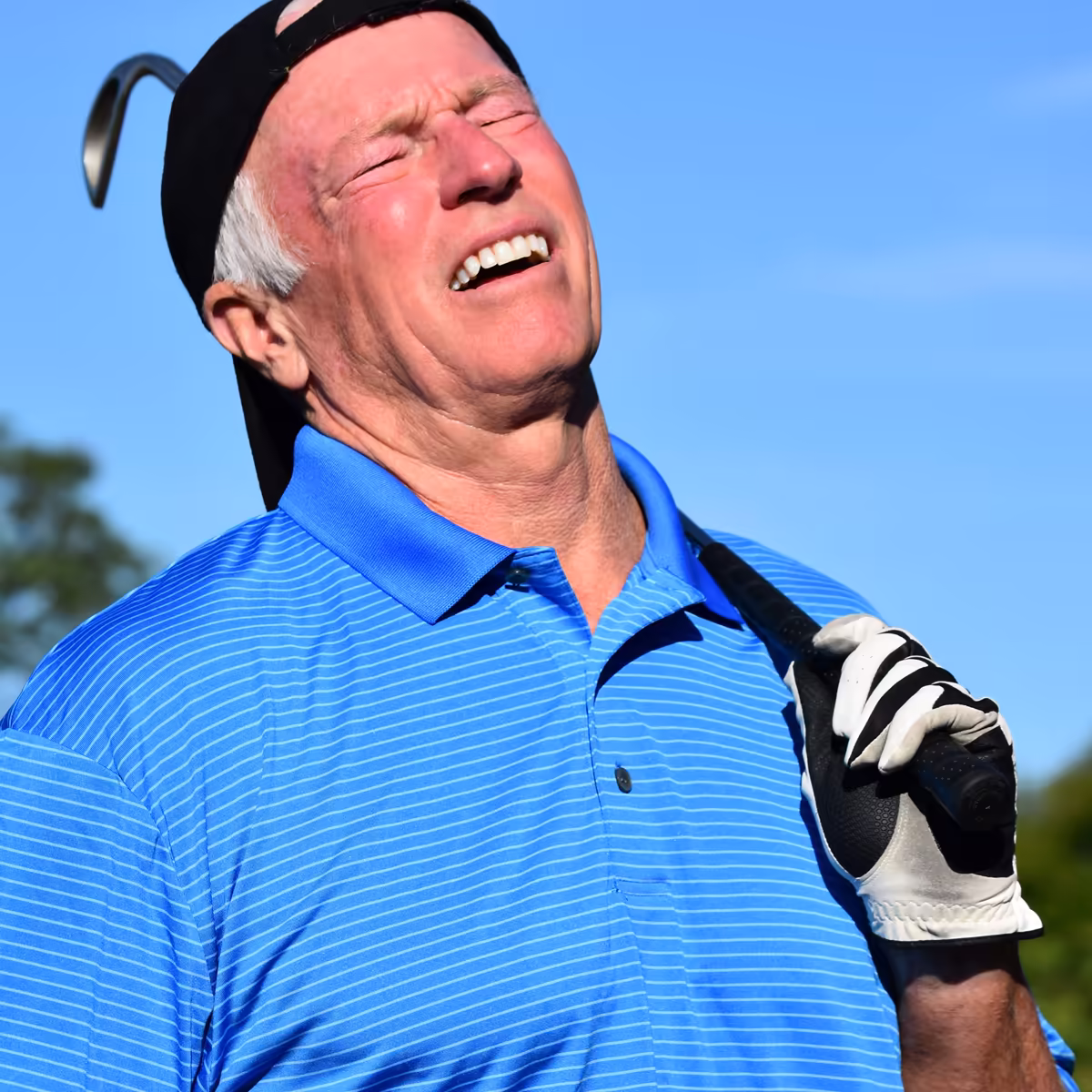 Older golfer holding his lower back and hip