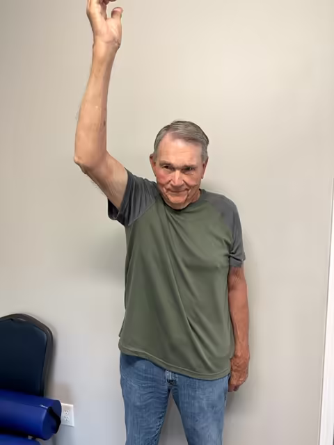 Patient raising his right arm overhead after three treatments