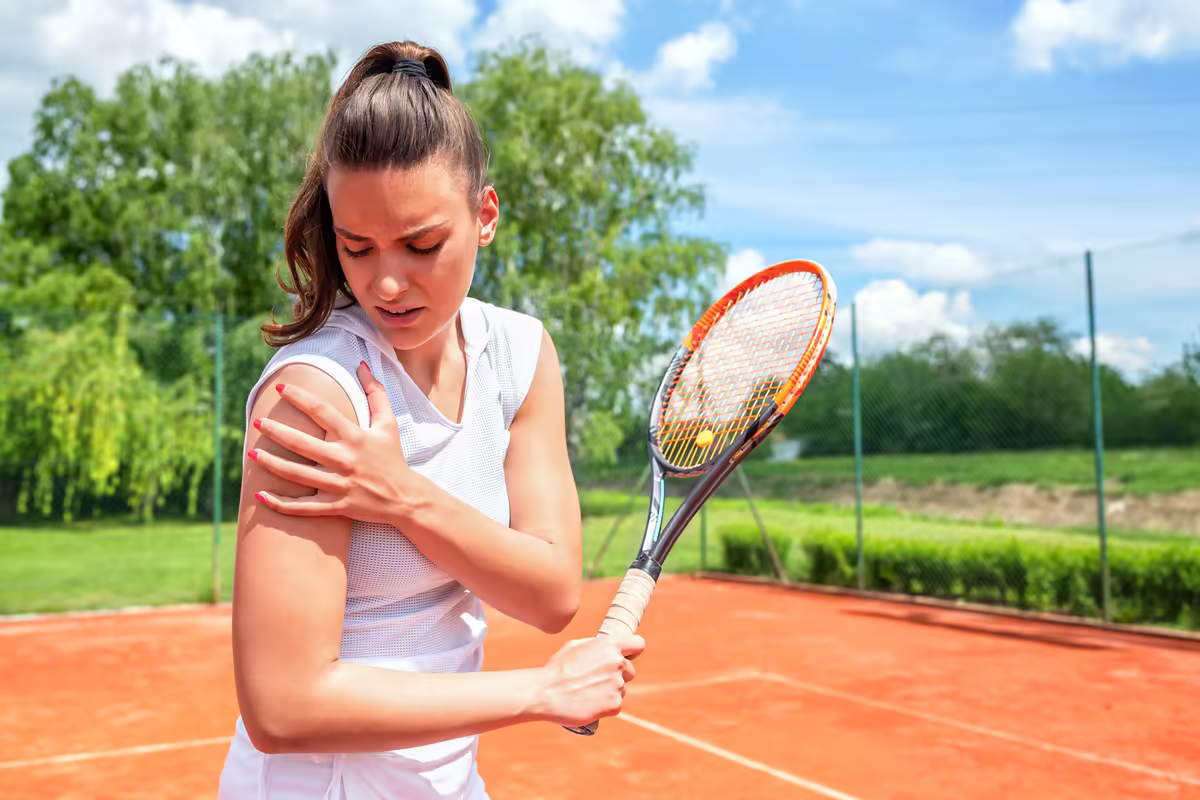 Tennis player holding her shoulder in pain