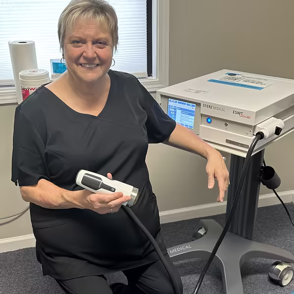Peggy Swann, RN, seated next to the DuoLith shockwave device
